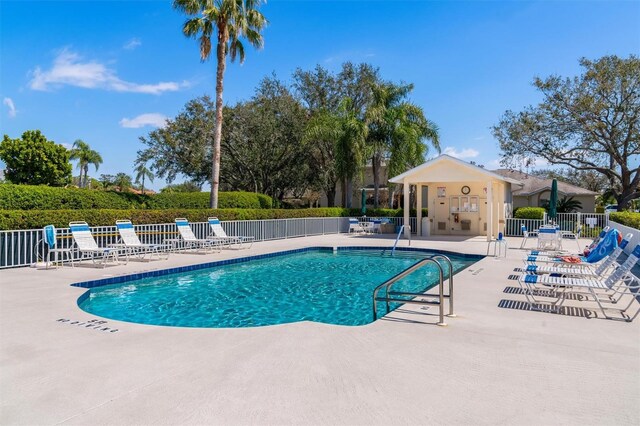 community pool featuring a patio and fence