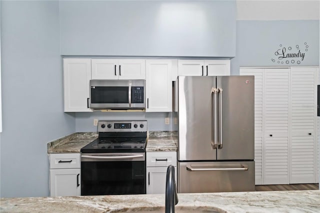 kitchen featuring stone counters, appliances with stainless steel finishes, and white cabinetry