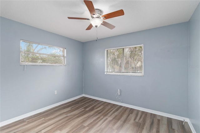 empty room featuring ceiling fan, baseboards, and wood finished floors