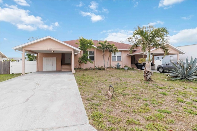 single story home with fence, driveway, stucco siding, a carport, and a front lawn