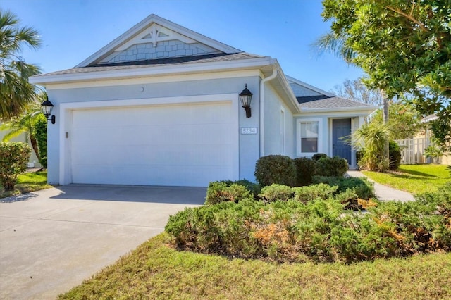 ranch-style house featuring a garage, driveway, and stucco siding