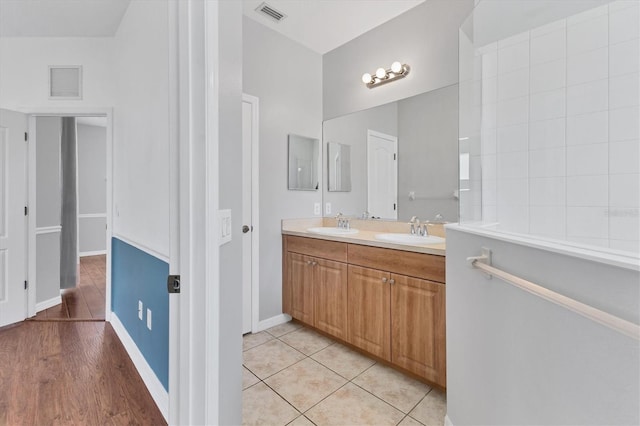 full bathroom with a sink, visible vents, double vanity, and tile patterned floors