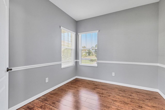 empty room featuring wood finished floors and baseboards