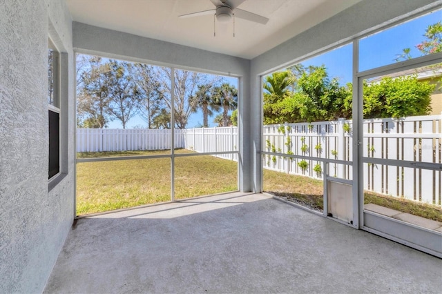 unfurnished sunroom featuring a ceiling fan and a healthy amount of sunlight