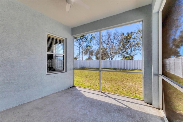 unfurnished sunroom featuring ceiling fan