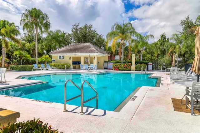 pool with a patio and fence