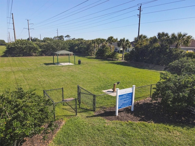 surrounding community featuring fence, a lawn, and a gate