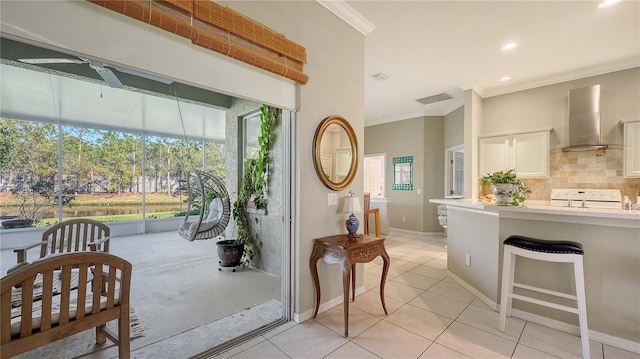 interior space featuring visible vents, ornamental molding, decorative backsplash, stove, and wall chimney exhaust hood