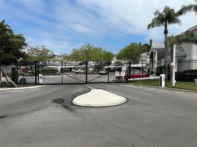 view of road with a gate, curbs, and a gated entry