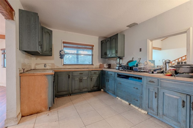 kitchen featuring light tile patterned floors, a textured ceiling, and light countertops