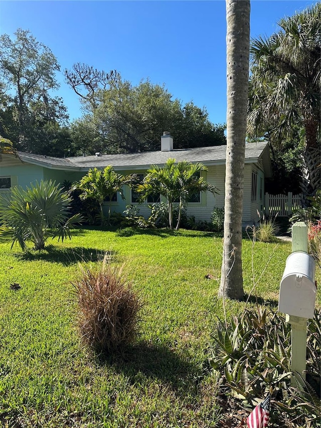 exterior space featuring a front lawn and a chimney