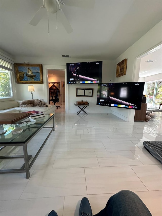 living area with ceiling fan and visible vents