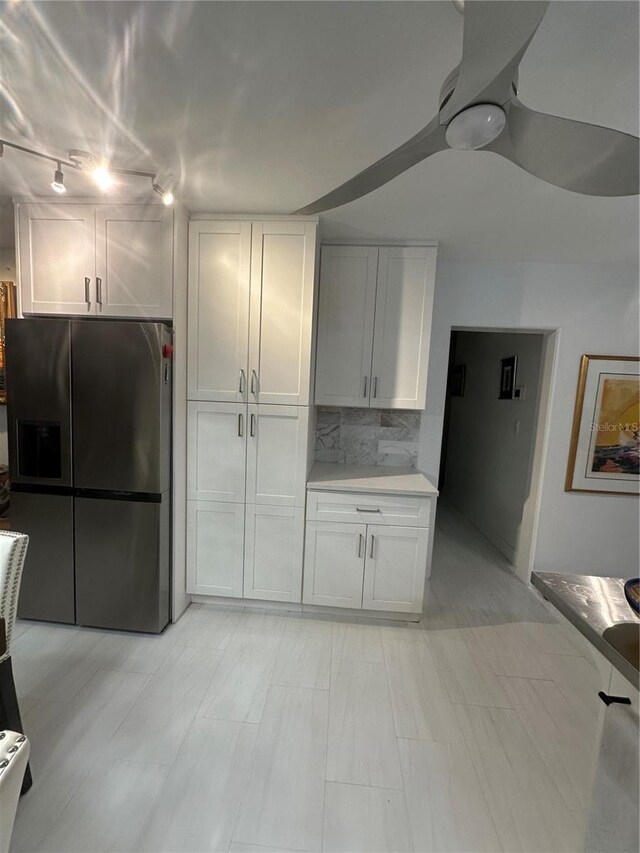 728 41st St, Sarasota, FL 34234 - kitchen featuring stainless steel refrigerator with ice dispenser, white cabinetry, light countertops, decorative backsplash, and rail lighting