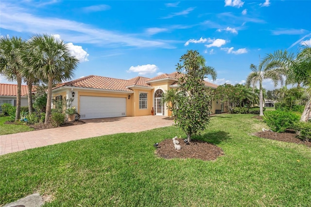 mediterranean / spanish house featuring stucco siding, a front lawn, a garage, a tile roof, and decorative driveway