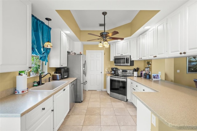 kitchen featuring visible vents, a peninsula, a sink, white cabinets, and appliances with stainless steel finishes