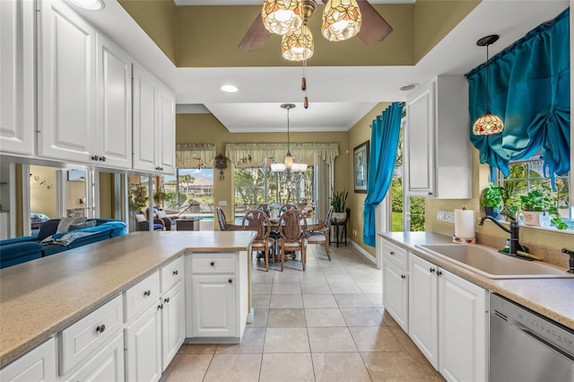 kitchen with a sink, white cabinetry, light countertops, and stainless steel dishwasher