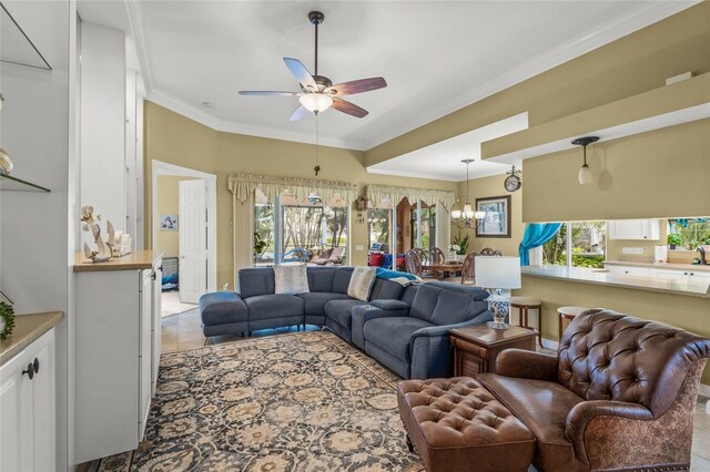 living room with ceiling fan with notable chandelier, light tile patterned floors, a healthy amount of sunlight, and ornamental molding