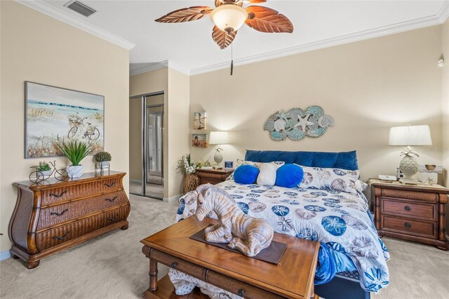 carpeted bedroom with visible vents, crown molding, baseboards, a closet, and a ceiling fan