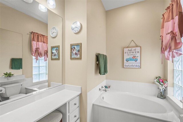 bathroom with vanity, toilet, and a bath