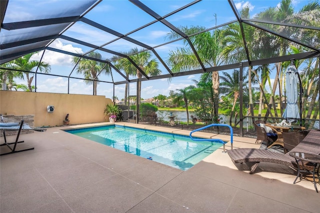 outdoor pool with a patio area, glass enclosure, and a water view