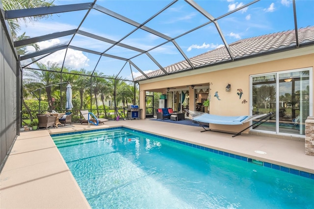 pool with glass enclosure, a patio, and area for grilling