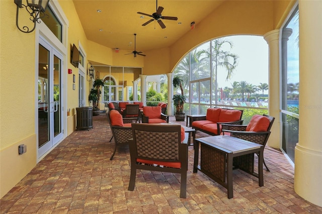 view of patio / terrace with glass enclosure, an outdoor hangout area, and ceiling fan