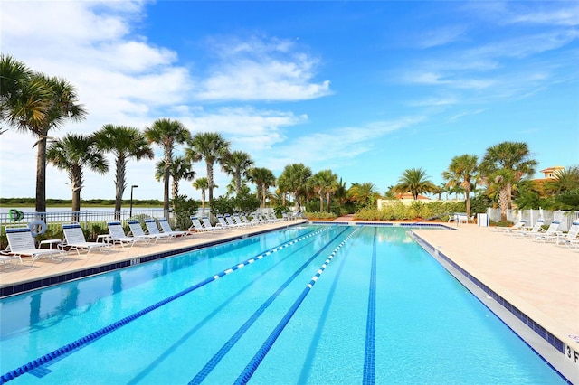 community pool with a patio and fence