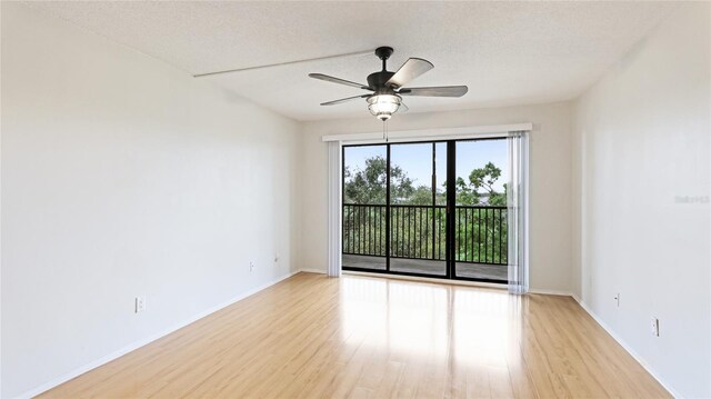 unfurnished room with baseboards, a textured ceiling, light wood-type flooring, and ceiling fan