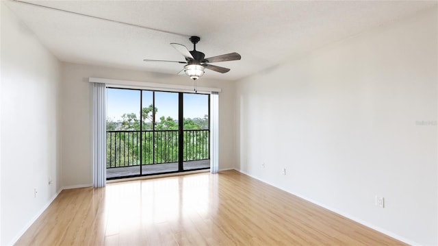 empty room featuring light wood-style flooring, a ceiling fan, and baseboards