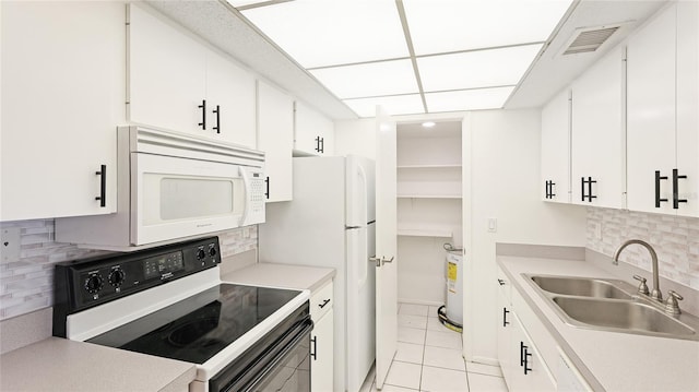 kitchen with white microwave, visible vents, light tile patterned floors, electric stove, and a sink