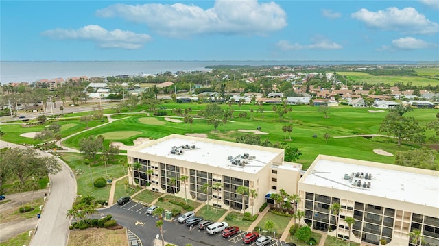 birds eye view of property with golf course view and a water view