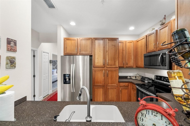 kitchen with visible vents, recessed lighting, brown cabinets, appliances with stainless steel finishes, and a sink