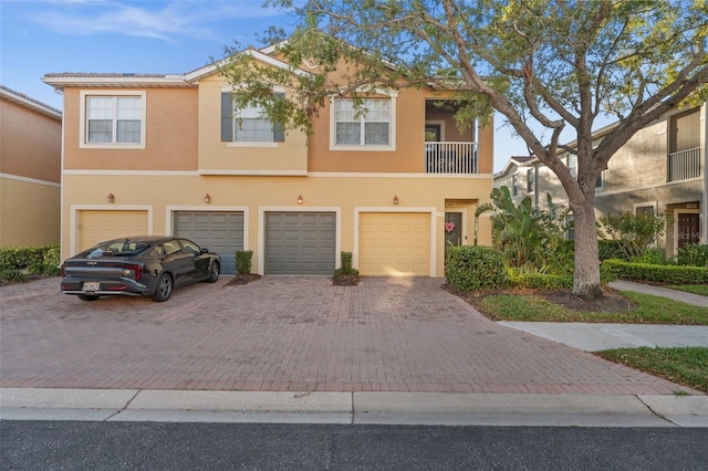 townhome / multi-family property featuring stucco siding, an attached garage, and driveway