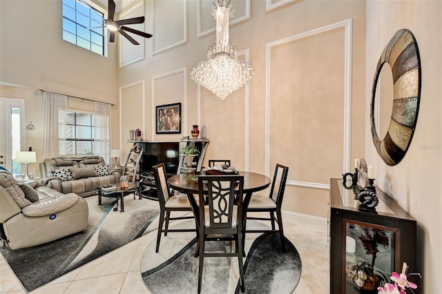 dining space featuring a wealth of natural light, baseboards, ceiling fan with notable chandelier, and light tile patterned floors