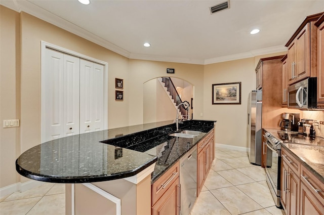 kitchen featuring visible vents, crown molding, arched walkways, stainless steel appliances, and a sink