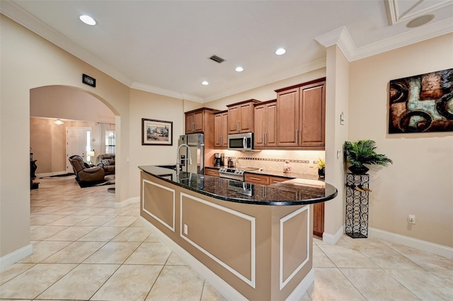 kitchen with visible vents, backsplash, arched walkways, appliances with stainless steel finishes, and crown molding