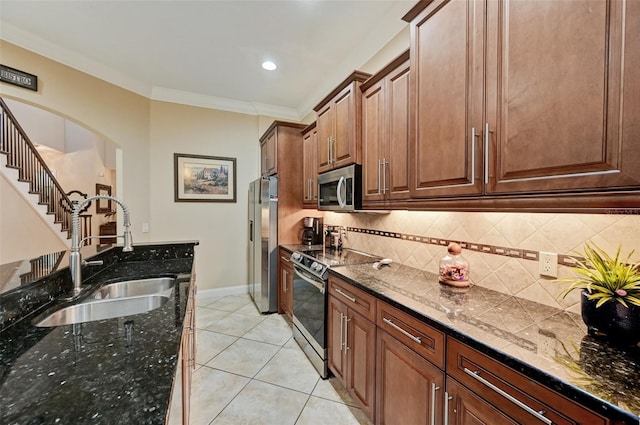 kitchen featuring crown molding, light tile patterned floors, decorative backsplash, stainless steel appliances, and a sink