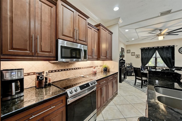 kitchen featuring crown molding, light tile patterned floors, appliances with stainless steel finishes, and a sink