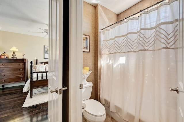 full bathroom featuring shower / bathtub combination with curtain, toilet, a ceiling fan, and wood finished floors