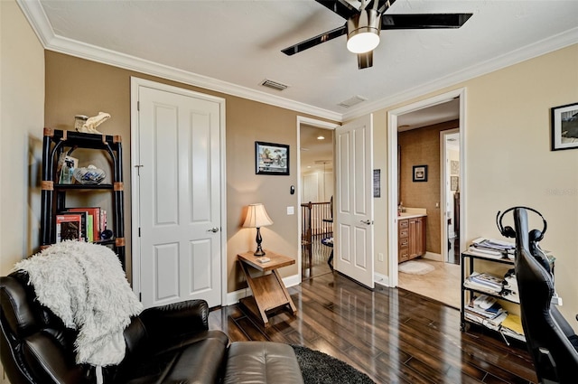 living area with visible vents, crown molding, and wood finished floors