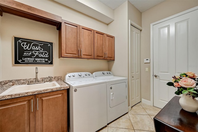 laundry area with washer and clothes dryer, light tile patterned floors, cabinet space, and a sink