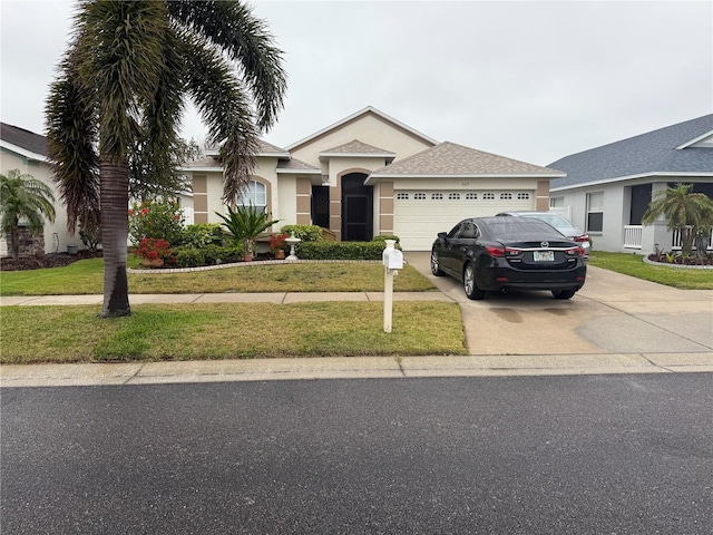 view of front facade with stucco siding, a front yard, concrete driveway, and an attached garage