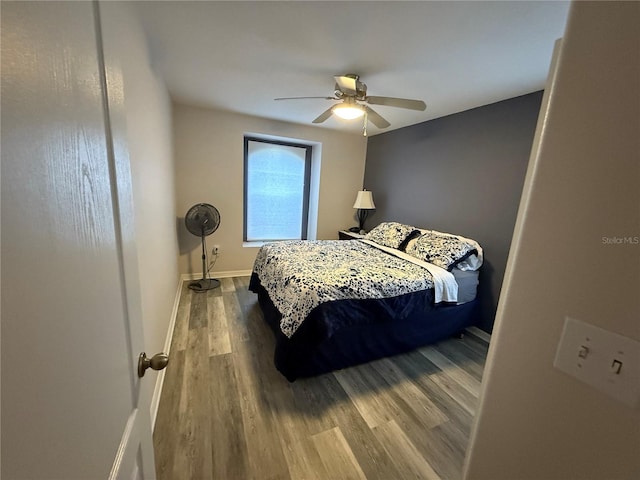 bedroom with baseboards, wood finished floors, and a ceiling fan