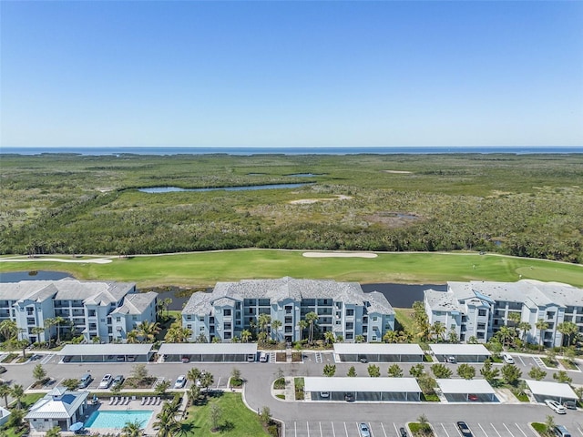 drone / aerial view with golf course view and a water view