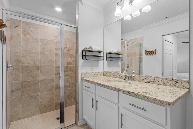 full bathroom with a stall shower, vanity, and ornamental molding