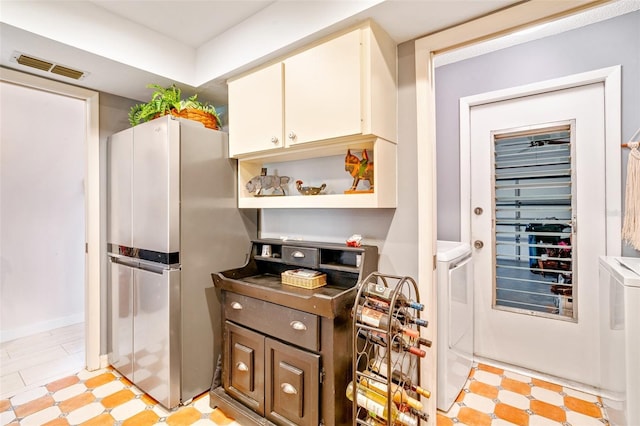 kitchen with light floors, independent washer and dryer, and freestanding refrigerator