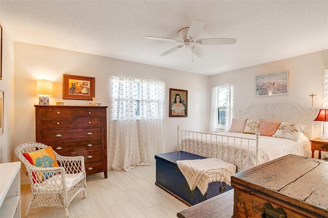 bedroom with ceiling fan and a textured ceiling