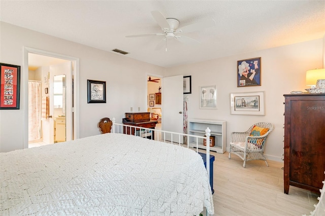 bedroom featuring a ceiling fan, visible vents, baseboards, ensuite bath, and light wood-style flooring