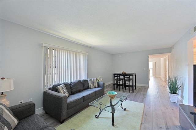 living room with baseboards and light wood finished floors