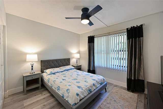 bedroom featuring ceiling fan, baseboards, and wood finished floors